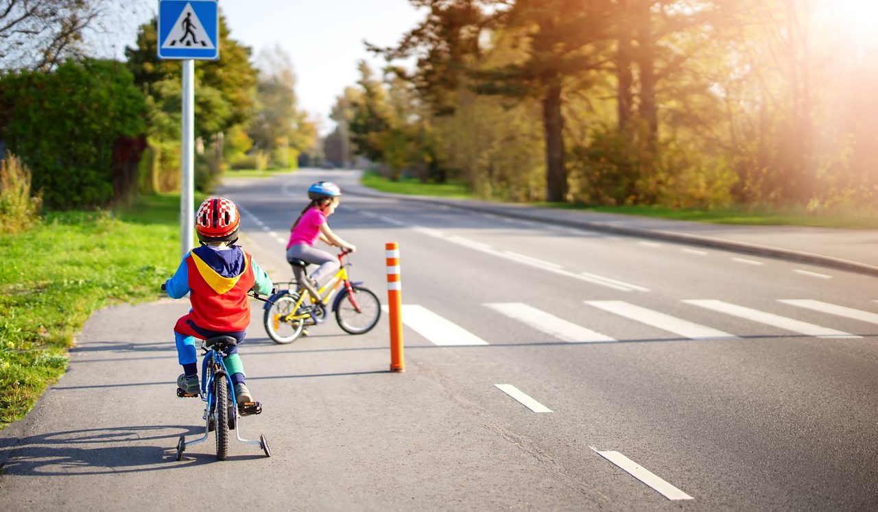Dos niños andando en bicicleta en el cruce peatonal