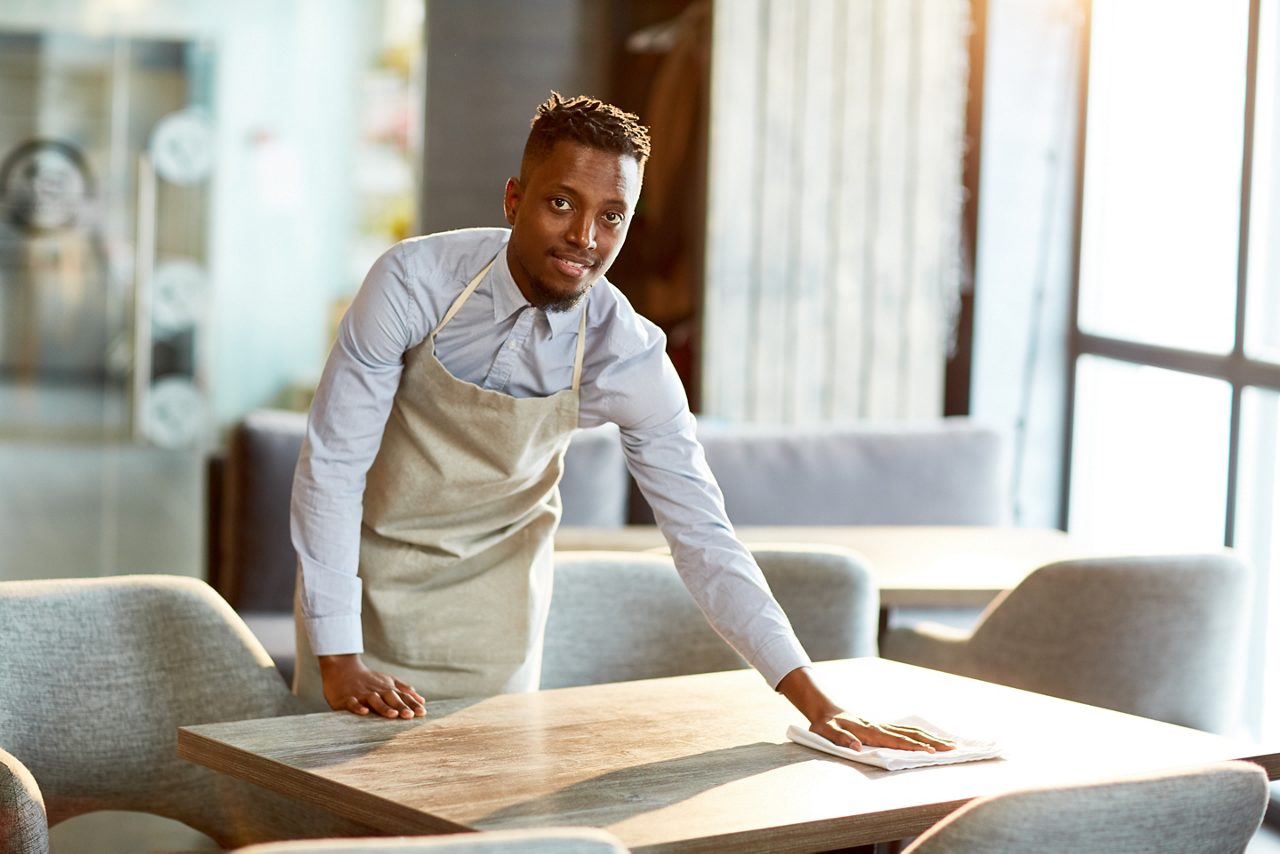 Chef limpando uma superfície rígida em uma cozinha comercial