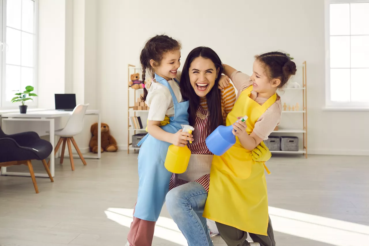 Woman and kids smiling and cleaning 