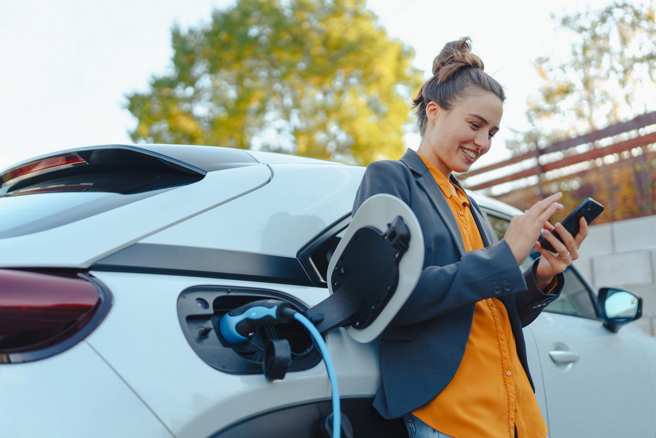 車を充電しているオレンジの女性