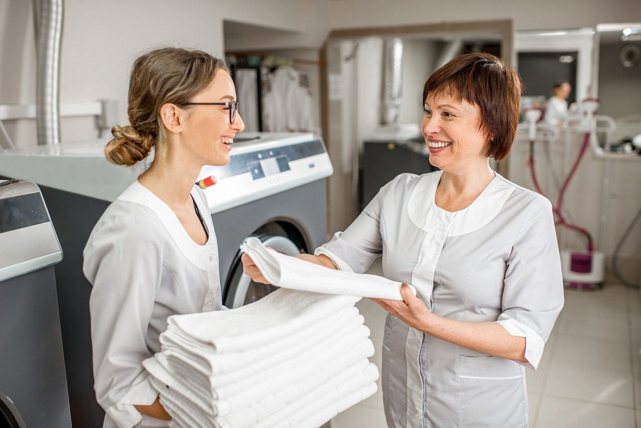 Two woman folding towels