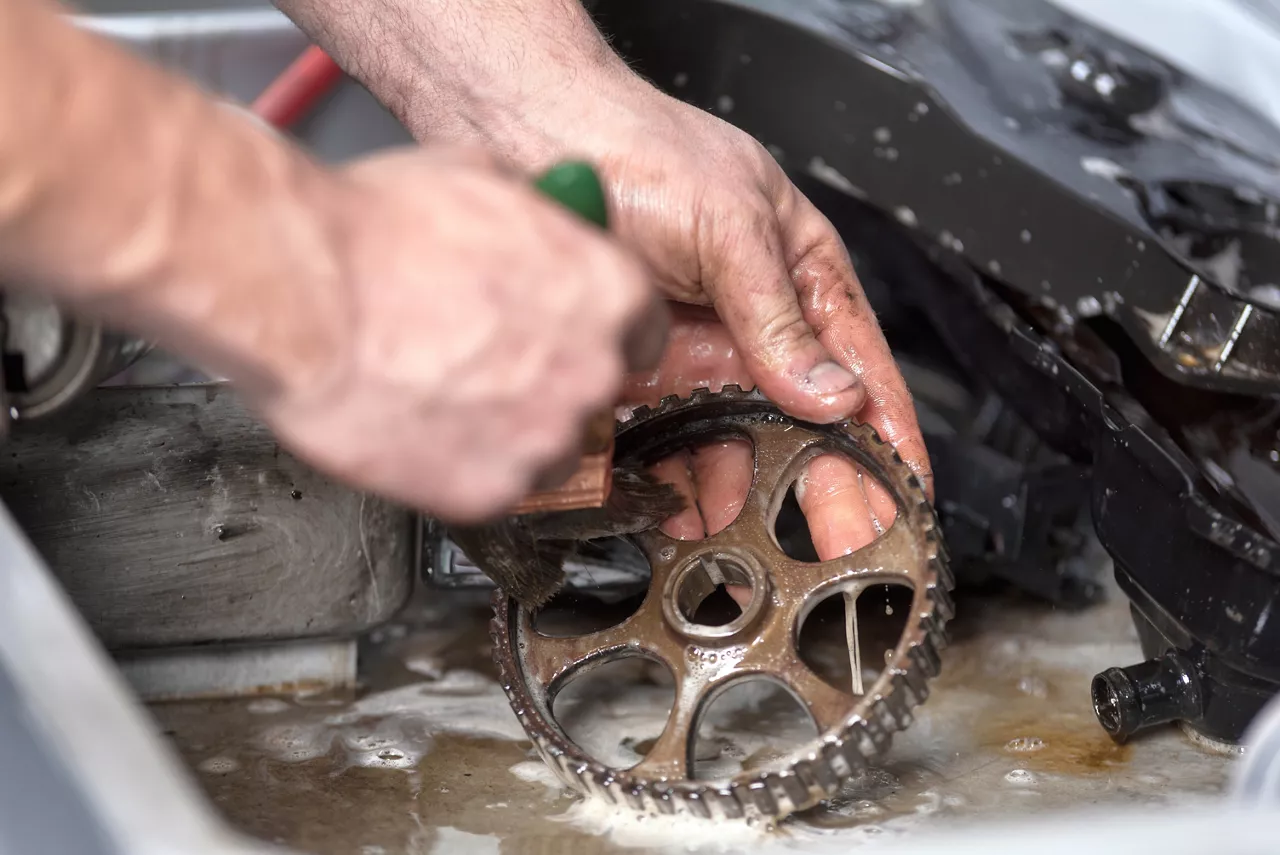 Person cleaning metal parts