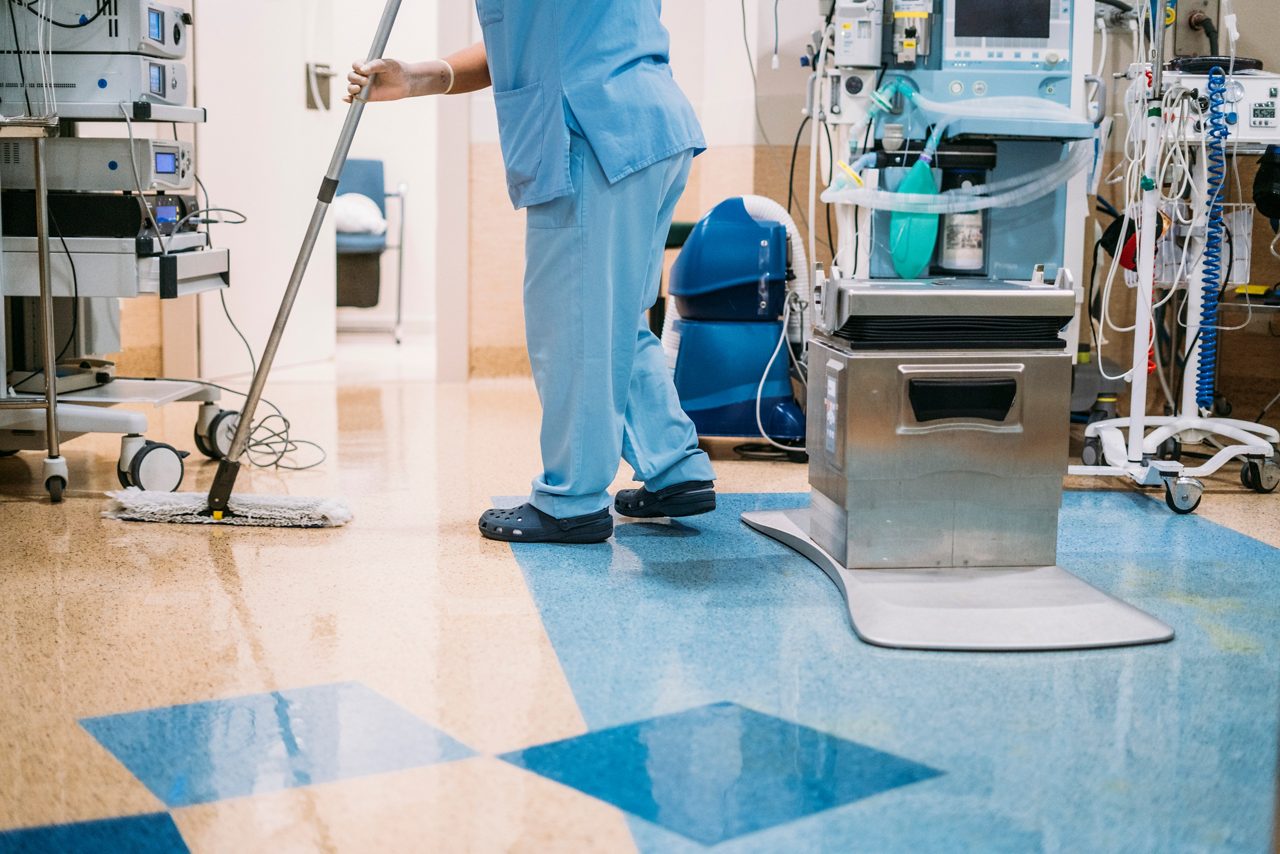 病院の手術室の床をモップで覆う病院の清掃スタッフ