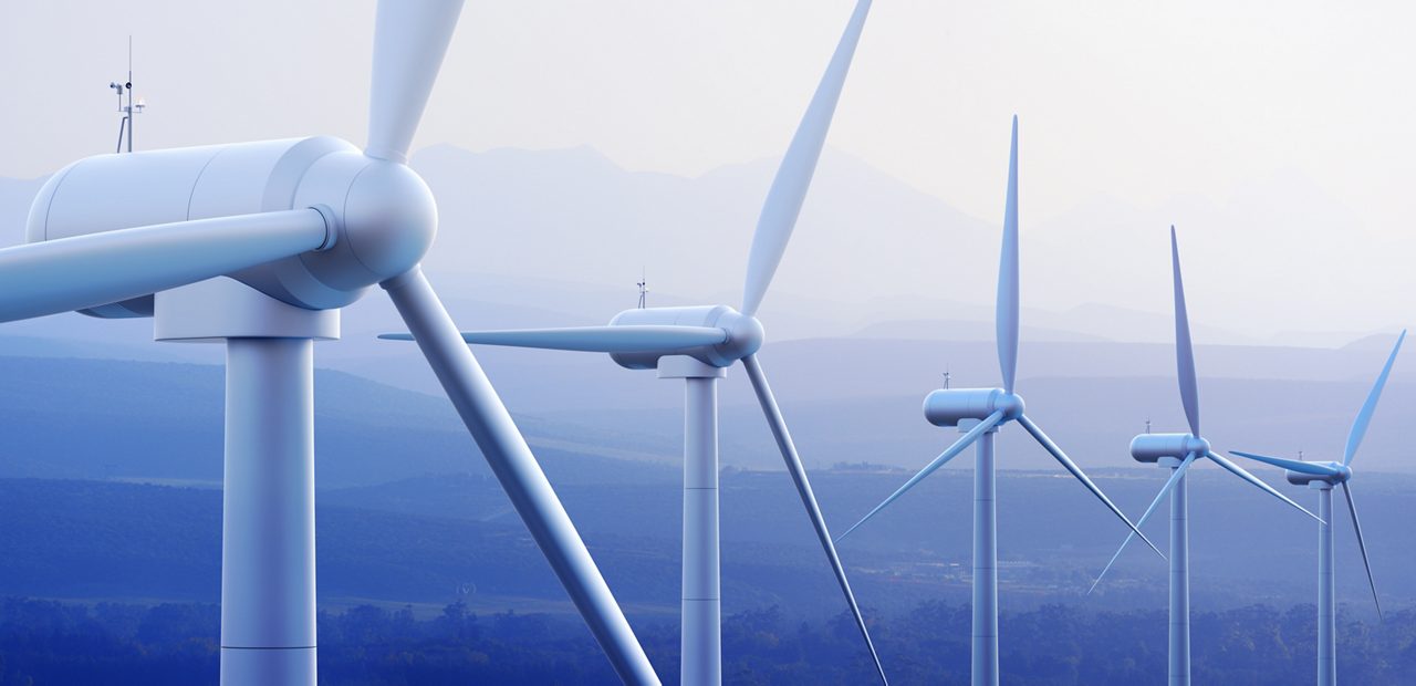Wind turbine farm against distant mountains