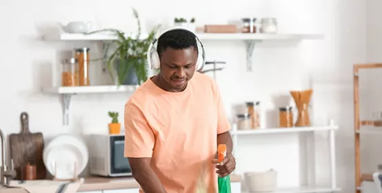 man listening to music while cleaning his kitchen