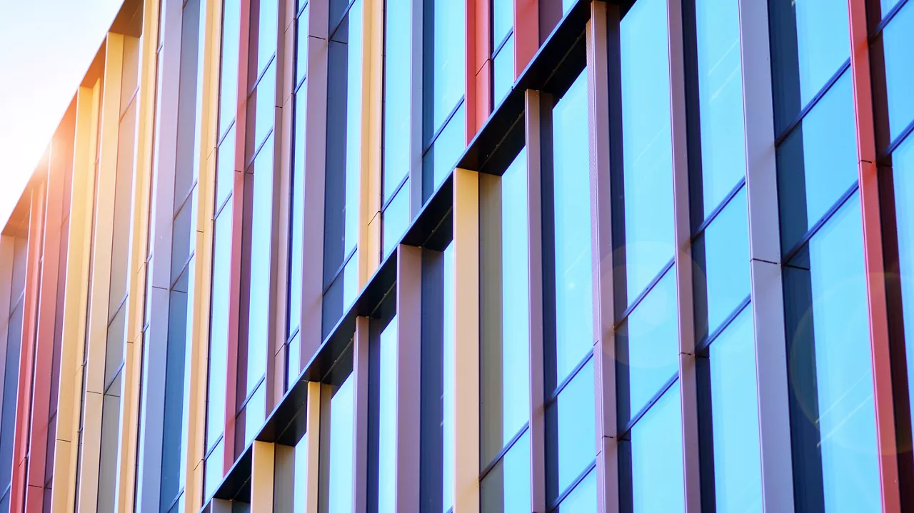Reflection of modern commercial building on glass with sunlight. Geometric structure glass windows