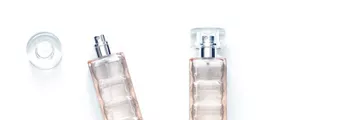 Two perfume bottles, transparent glass spray and bottle cap isolated on white background | K2025 color edit