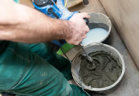 A construction worker mixes a special tile adhesive.