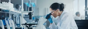 Female Scientist Looking Under Microscope, Analyzes Petri Dish Sample. Specialists in Medicine