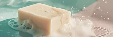 A soap bar sits atop a surface covered in foamy bubbles