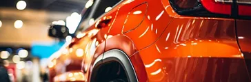Close-up of modern vehicles displayed for sale at a bustling car dealership showroom