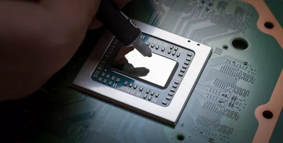 A technician squeezes fresh thermal paste onto the CPU