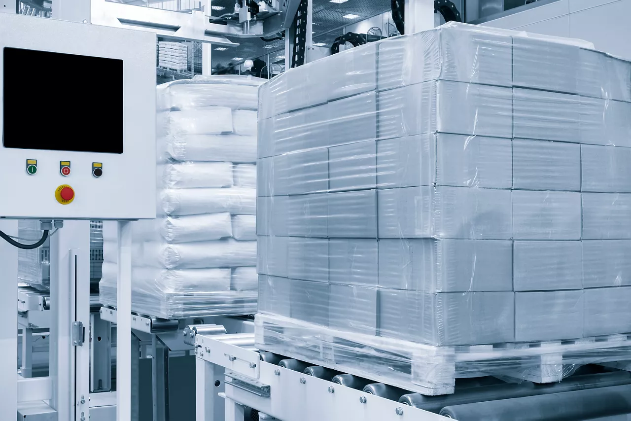 Cardboard boxes on a pallet wrapped in plastic wrap ready for delivery in a warehouse, logistics warehouse delivery concept background