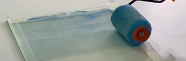 DOWSIL™ 650+ being applied with roller to glass pane