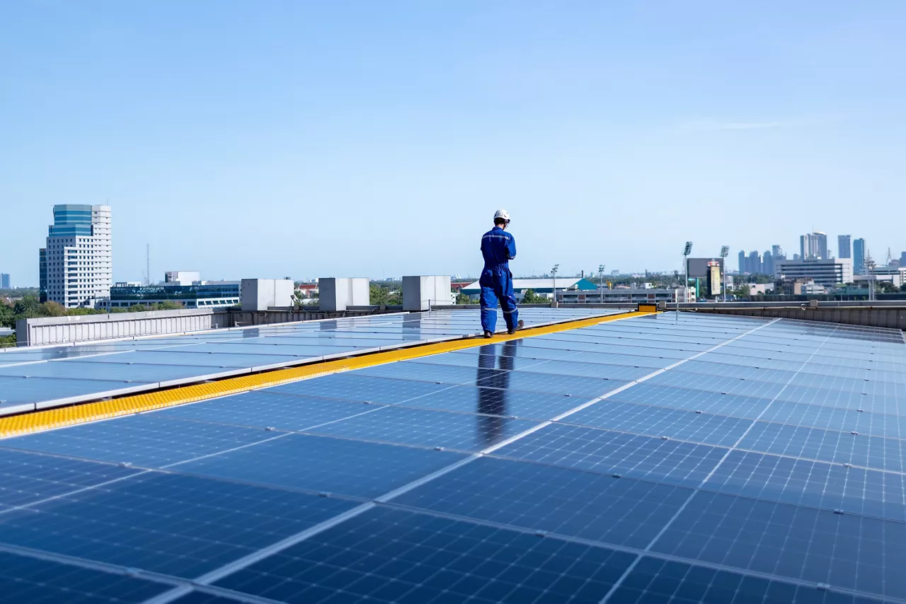 Engineers walking on roof inspect check and Maintenace solar cell panel by hold blue print  ,solar cell is smart grid ecology energy sunlight alternative power factory concept.