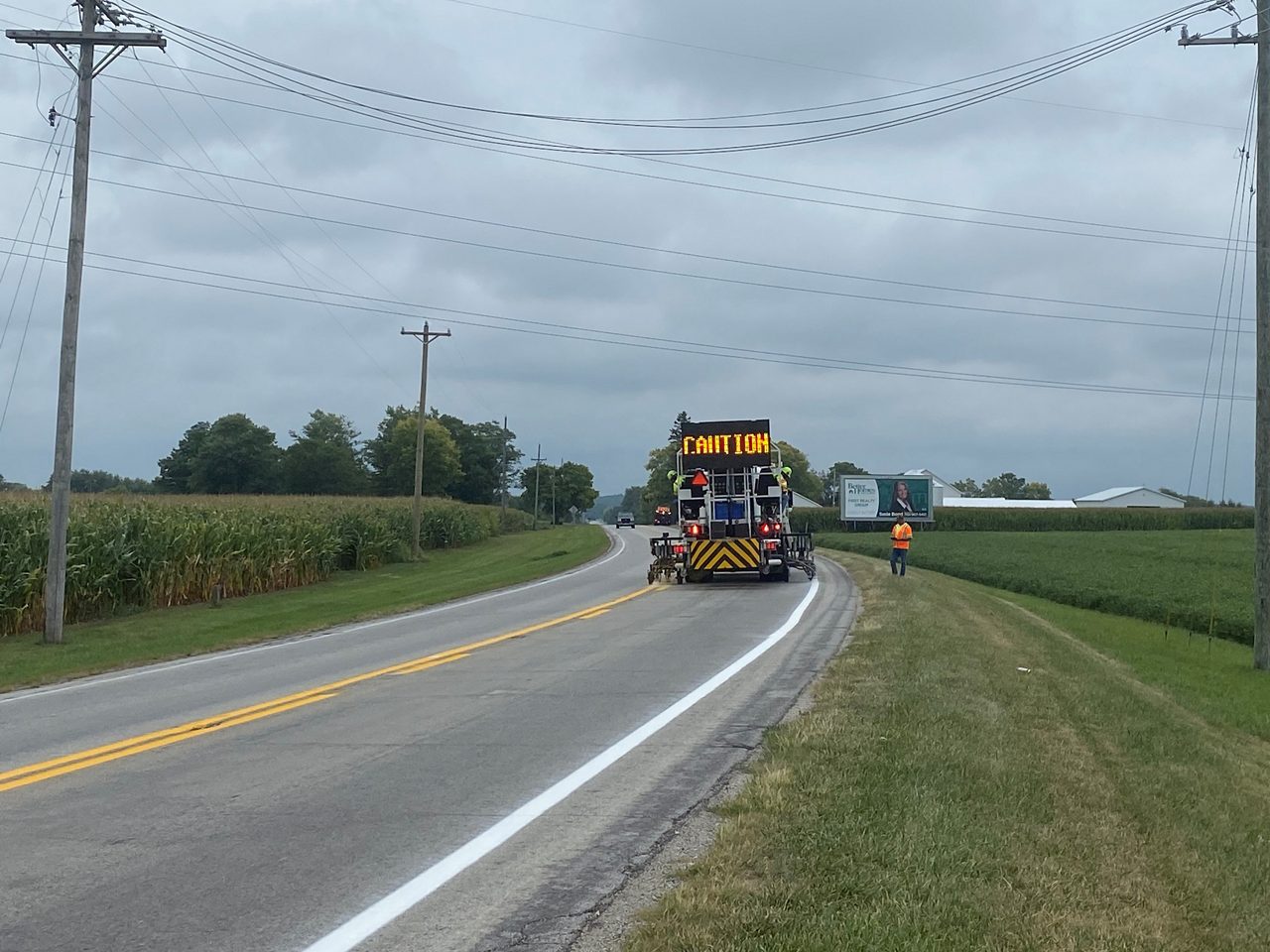 Pavement marking vehicle applying paint to highway