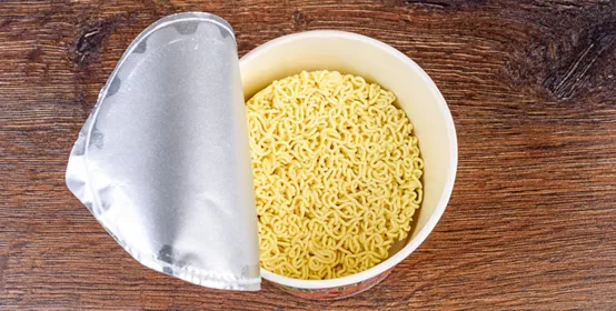 Open lid with dry instant noodles without spices. Copy space.