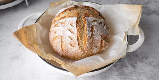 Sourdough loaf on a tan baking sheet