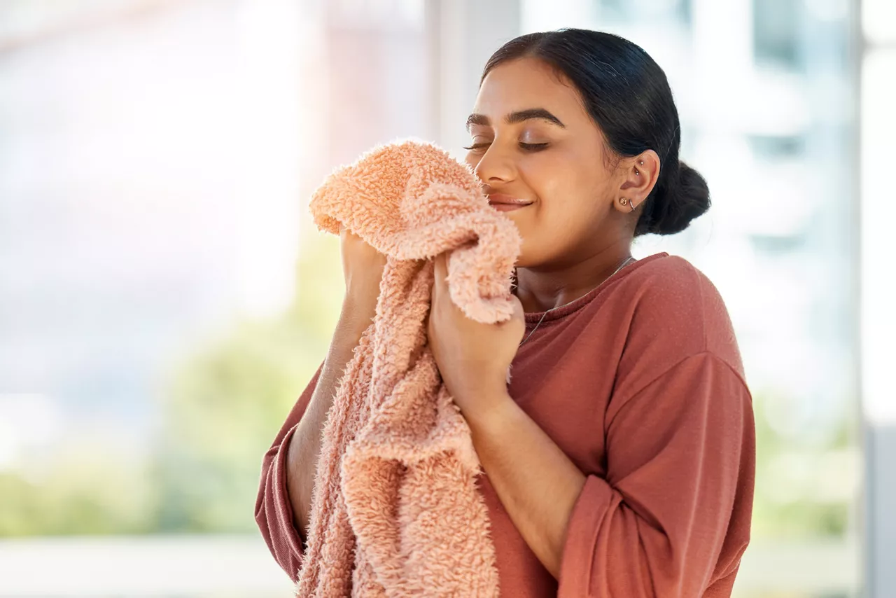 Woman smelling clean laundry for fresh and clean smell after doing washing