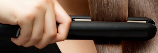 Straightener in a woman’s hair