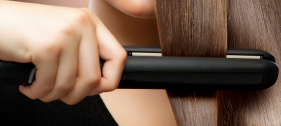 Straightener in a woman’s hair