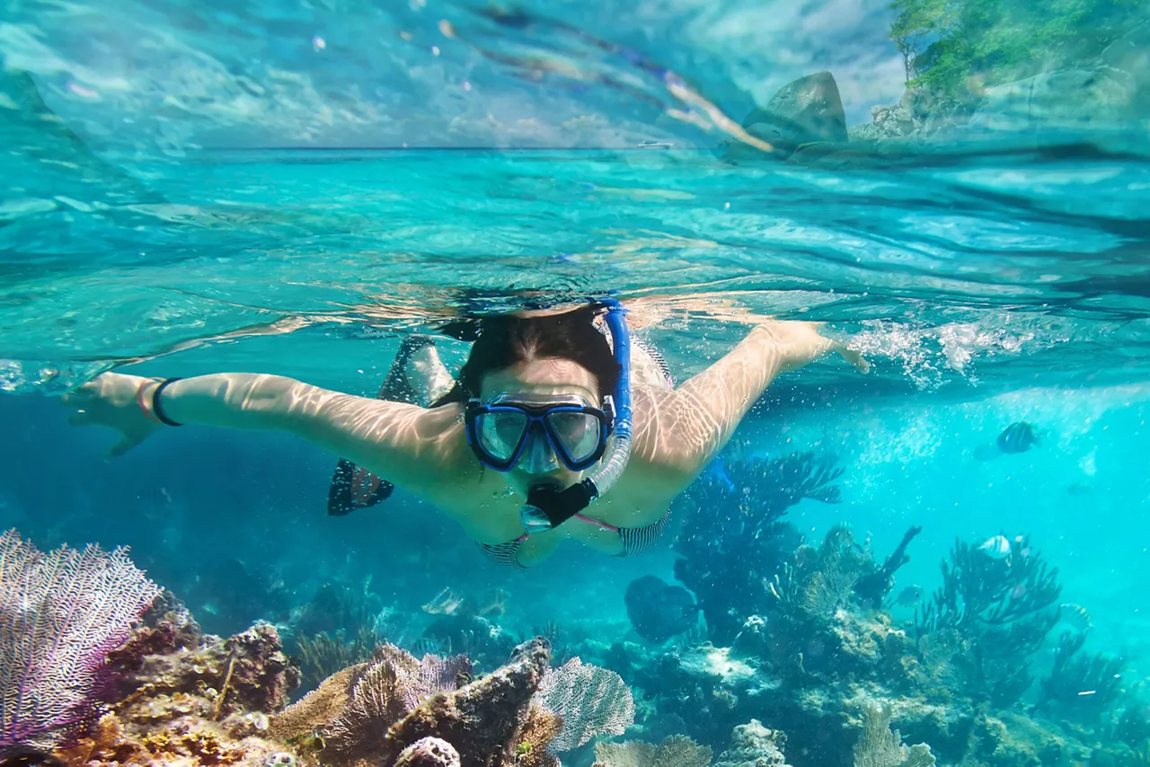 Young woman at snorkeling in the tropical water