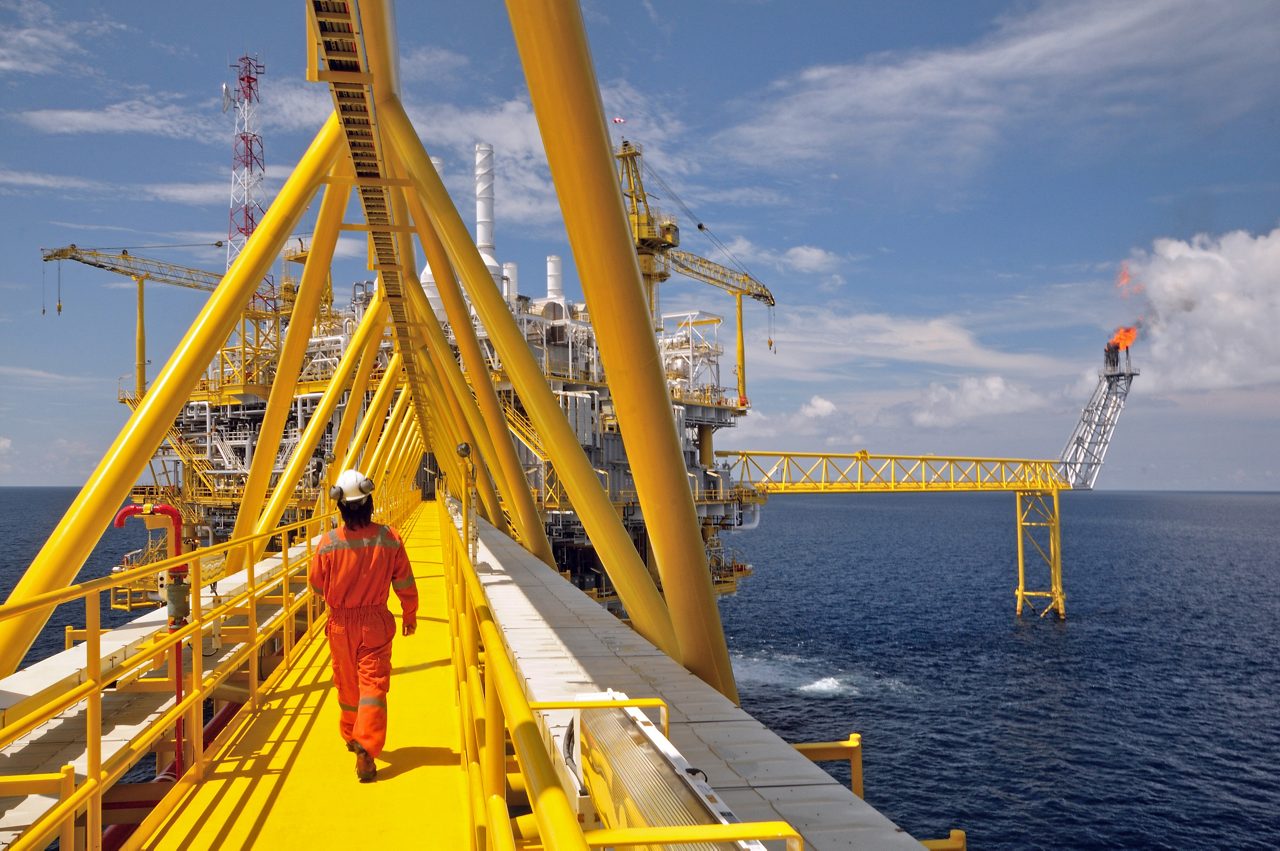 Operator walking operation of oil and gas process at oil and rig plant 