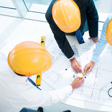 Three employees looking at blueprints and schematics