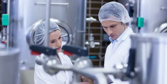 Employees in white uniforms and hairnets