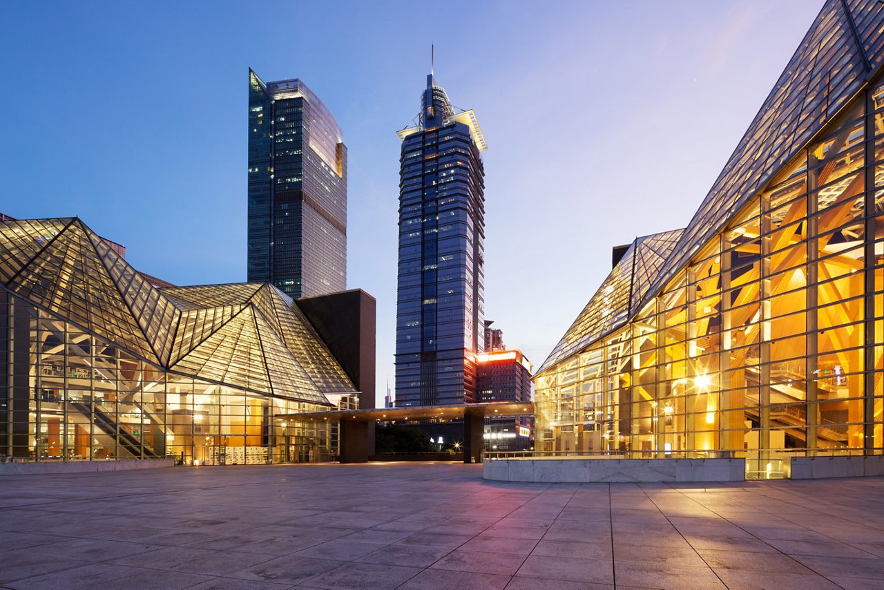 Lights glowing through glass panels on buildings at dusk