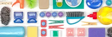 Flat lay of various cleaning supplies on white background 