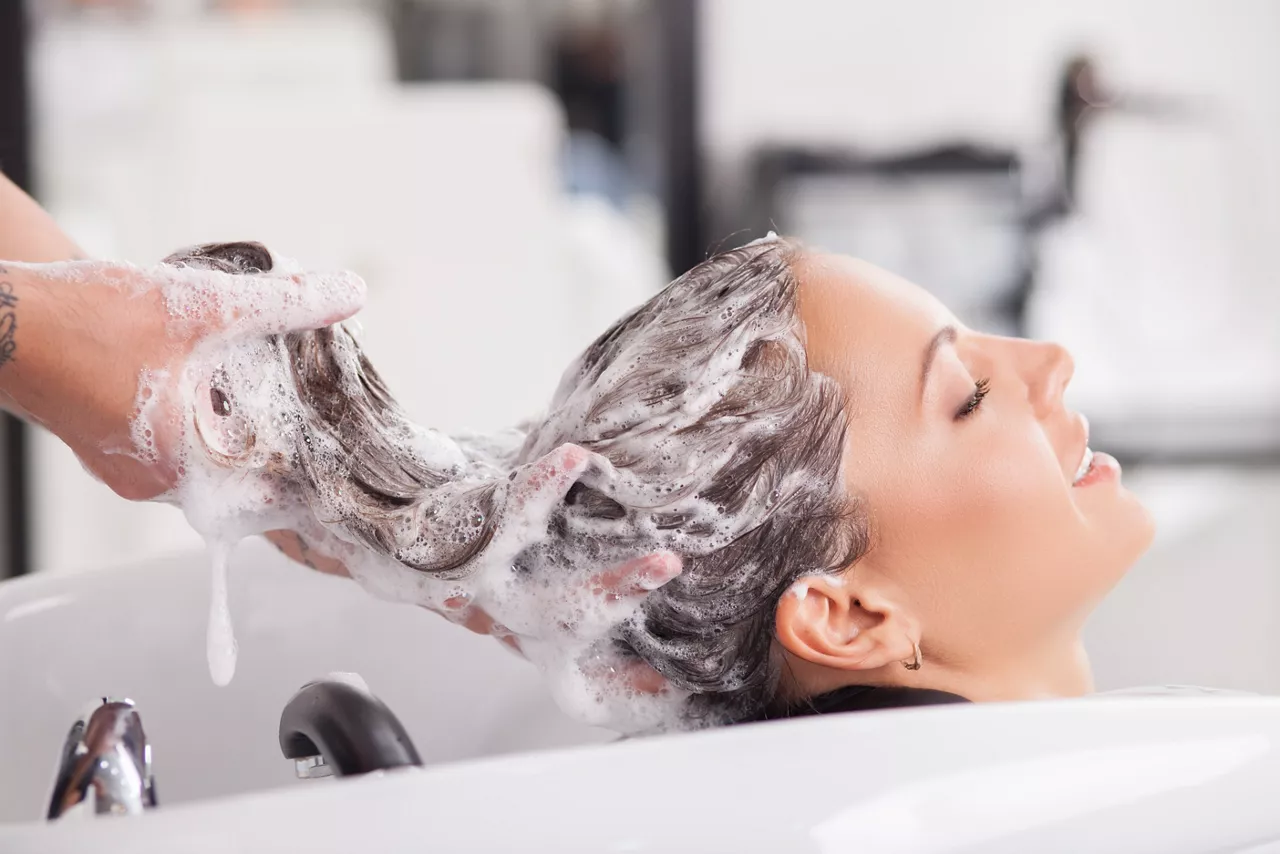 Close up of woman is getting hair washed by a hairdresser