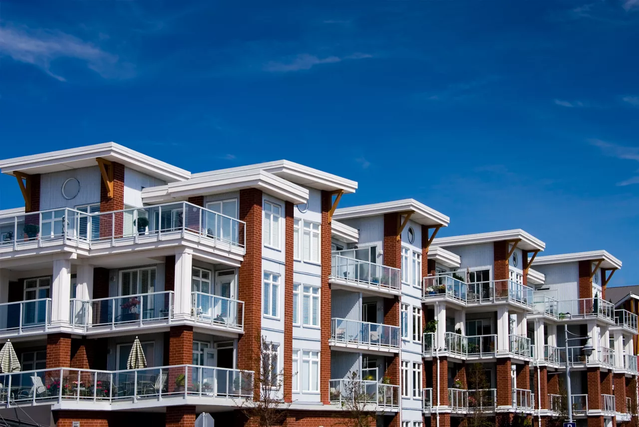 A large apartment building and a blue sky.